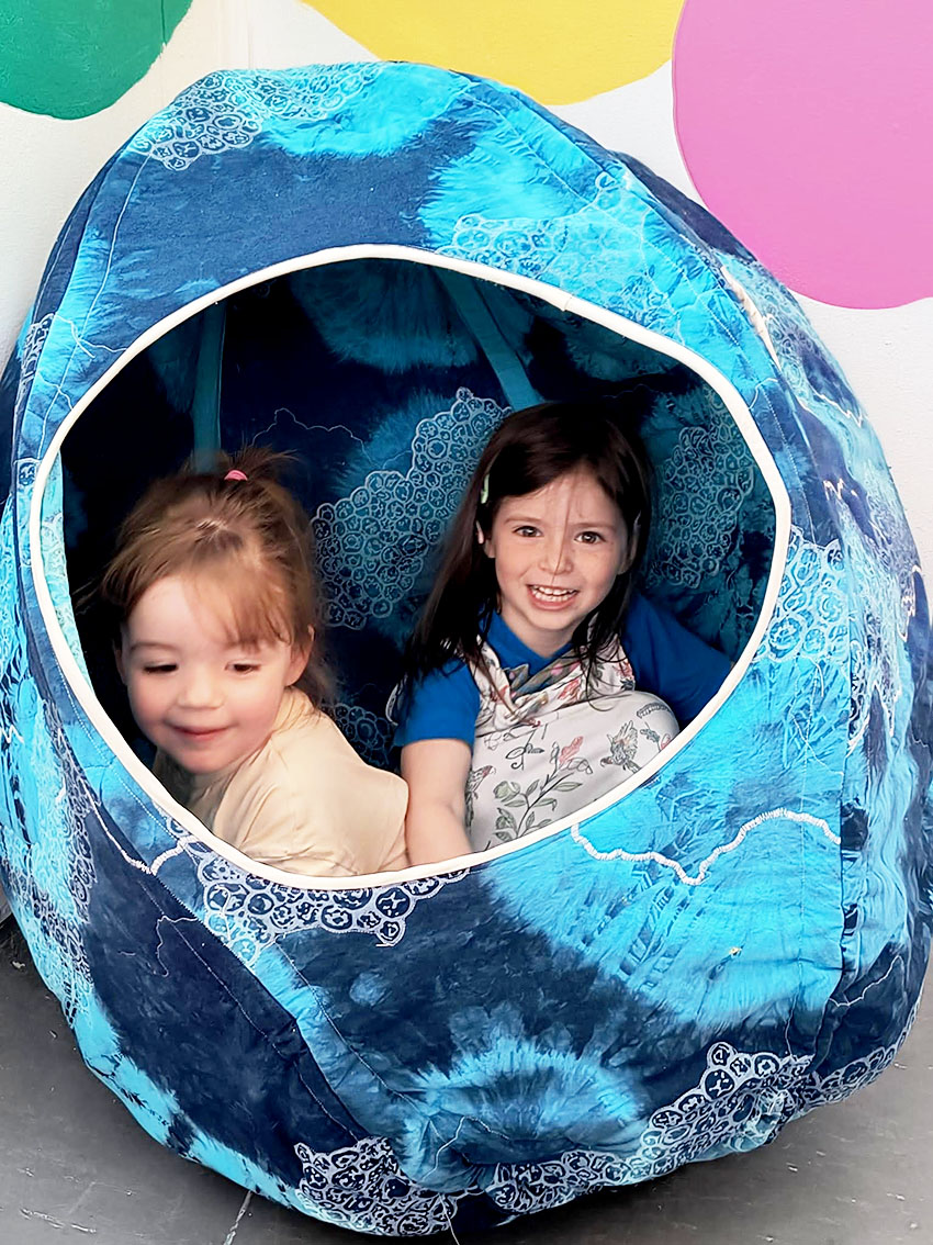 Children hiding in a quilted den